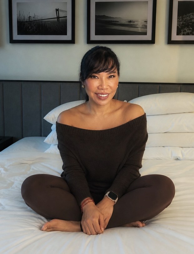 Odette Orola, smiling, sitting cross-legged and relaxed